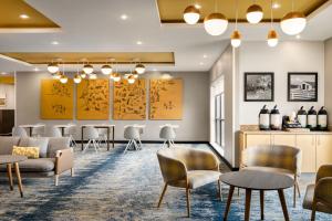 a waiting room with chairs and tables at TownePlace Suites by Marriott Harrisburg West/Mechanicsburg in Mechanicsburg
