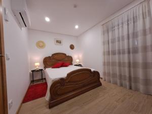 a bedroom with a large wooden bed with two lamps at Burguesinha AL Entre-os-Rios in Entre-os-Rios
