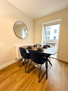 a dining room with a table with chairs and a mirror at Modern spacious 2 bed Apartment, close to Gunwharf Quays & Historic Dockyard - Balcony, Smart Tv, Free Parking, WiFi, Double or single beds in Portsmouth