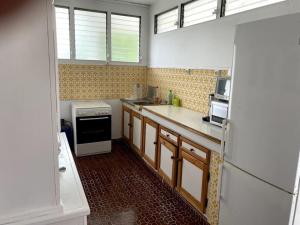 a kitchen with a stove and a refrigerator at La Villa Ti-Louise à Marie-Galante in Grand-Bourg