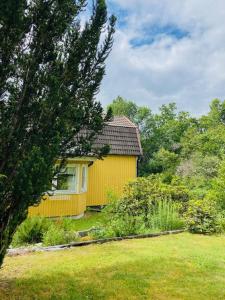 una casa amarilla en un patio con un árbol en Mark Villan en Örebro