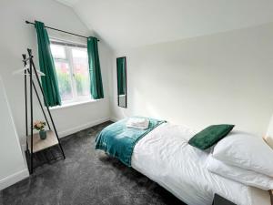 een slaapkamer met een bed en een raam met groene gordijnen bij Perfect for Contractors & Families! 7 Beds Free Parking in Birmingham