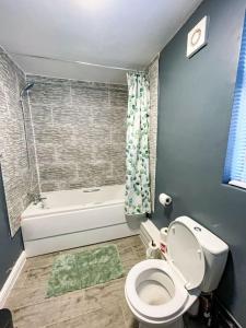a bathroom with a toilet and a bath tub at Perfect for Contractors & Families! 7 Beds Free Parking in Birmingham