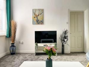 a living room with a vase of flowers on a table at Perfect for Contractors & Families! 7 Beds Free Parking in Birmingham
