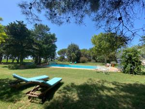 uma piscina com duas espreguiçadeiras na relva em Mas Antonine Cigalle em Arles