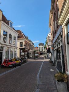 烏特勒支的住宿－Monumental gem in the heart of Utrecht City，街上的一条街道,有摩托车停在街上