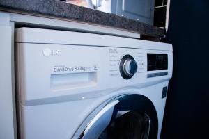 een wasmachine met een magnetron erop bij Cozy Flat Reading City Centre Available for Contractors in Reading