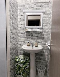 La salle de bains est pourvue d'un lavabo et d'un miroir. dans l'établissement Appartement Jnane Awrad, Marrakech, à Marrakech