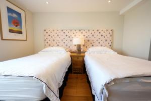 zwei Betten nebeneinander in einem Zimmer in der Unterkunft Fleur de Sel - Upside Down Cottage with Spectacular View & Parking in Brixham