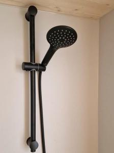 a black shower head hanging on a wall at Cabana auf dem Biohof Hornen 