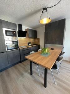 cocina con mesa de madera en una habitación en Joli T3 entre Genève et Chamonix, en Cluses