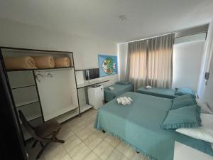 um quarto com uma cama azul e um sofá em Shallom Hotel em Balneário Camboriú