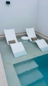two white chairs and a toilet in a room at Villa Siena, in the center of Playa del Ingles, close to CC Jumbo in Maspalomas