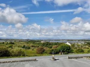 An Chéibh B&B في Rossaveel: موقف سيارات فارغ مع السماء الزرقاء والغيوم