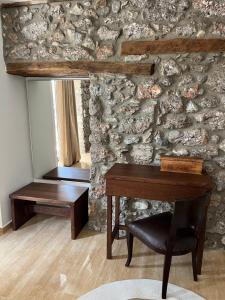 a room with a desk and a stone wall at Olympus Stone Lodge in Litochoro