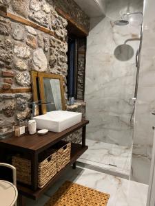 a bathroom with a sink and a mirror at Olympus Stone Lodge in Litochoro