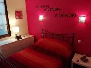 um quarto vermelho com uma cama com uma parede vermelha em La Perle du Rouergue em Villefranche-de-Rouergue