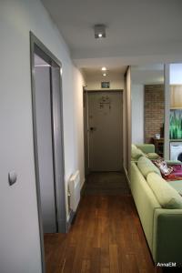 a living room with a green couch and a door at Apartament Anna in Srebrna Góra