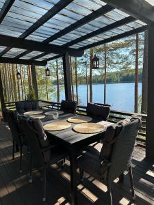 a table and chairs on a deck with a view of a lake at Cityvilla on the shore of Lake Haapajärvi in Joensuu