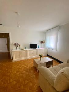 uma sala de estar com um sofá e uma televisão em A casa do pai em Pontevedra