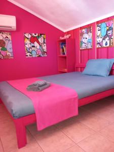 モラ・カリヴァにあるMagic Molaのピンクの壁のベッドルーム1室、ピンクの毛布付きのベッド1台が備わります。