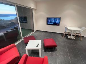 a living room with red chairs and a tv at La Merle in Veyrier-du-Lac +6 photos