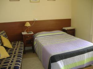 a small bedroom with a bed and a chair at Residência Ideal in Coimbra