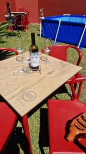 a wooden table with glasses and a bottle of wine on it at Vila Henrique Country Cottage in Fajã da Ovelha