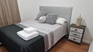 a bedroom with a bed with pillows and a night stand at Vila Henrique Country Cottage in Fajã da Ovelha +28 photos