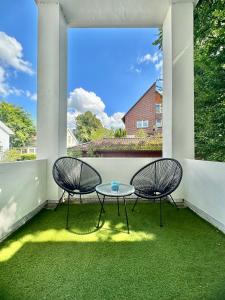 two chairs and a table on a patio at Exklusives City-Apartment im Herzen Oldenburgs mit Balkon und Parkplatz A36 in Oldenburg +24 photos
