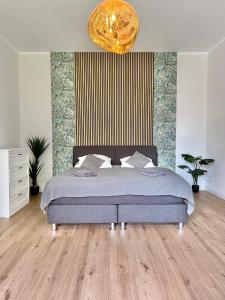 1 dormitorio con cama y lámpara de araña de oro en Exklusives City-Apartment im Herzen Oldenburgs mit Balkon und Parkplatz A36, en Oldenburg