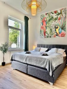 1 dormitorio con 1 cama grande y una pintura en la pared en Exklusives City-Apartment im Herzen Oldenburgs mit Balkon und Parkplatz A36, en Oldenburg