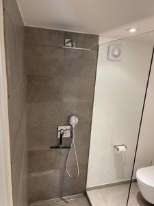 uma casa de banho com chuveiro e WC em Nyistandsat højloftet kælderlejlighed på 70 m2 i Viborg centrum, med plads til 4 personer em Viborg