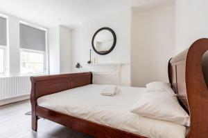 Schlafzimmer mit einem Bett und einem Spiegel an der Wand in der Unterkunft Gorgeous London Town House Sleeps up to 8 in London