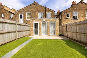 a yard with a fence and a house at Gorgeous London Town House Sleeps up to 8 in London