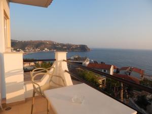 a balcony with a table and a view of the ocean at Bel Air Rooms in Himare