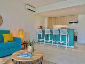 a living room with a blue couch and a kitchen at Appartement duplex Kakoon Saint Martin Anse Marcel in Anse Marcel 
