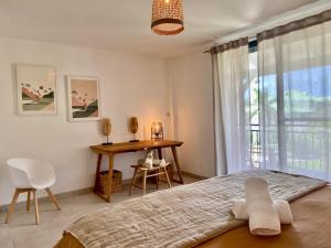 una camera da letto con un letto, un tavolo e una finestra di Appartement duplex Kakoon Saint Martin Anse Marcel ad Anse Marcel