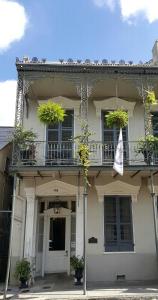 ein weißes Haus mit Topfpflanzen auf einem Balkon in der Unterkunft Inn on St. Ann, a French Quarter Guest Houses Property in New Orleans