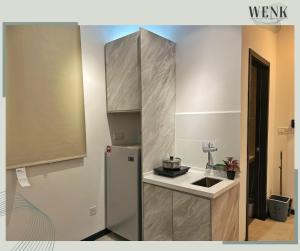 a small kitchen with a refrigerator and a sink at Neu Suites @ 3RdNvenue A in Kuala Lumpur