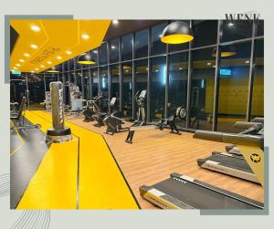 a gym with treadmills and machines on a wooden floor at Neu Suites @ 3RdNvenue A in Kuala Lumpur