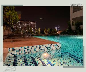 a swimming pool with a tiled floor at night at Neu Suites @ 3RdNvenue A in Kuala Lumpur