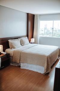 1 dormitorio con cama grande y ventana grande en Hotel Serrano, en Campina Grande