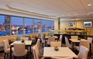 a restaurant with tables and chairs and a view of the city at Sheraton Inner Harbor Hotel in Baltimore