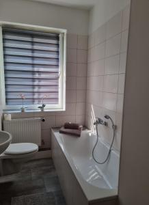 a bathroom with a tub and a toilet and a sink at Modern-Ruhig-Stadtnah-Geschirrspüler-Parkplatz in Pasewalk