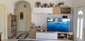 a living room with a flat screen tv on a table at Country House Bubullime Albania (Villa - Cottage) in Lushnjë