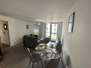 曼徹斯特的住宿－Beautiful Manchester 2 bedroom apartment，客厅配有桌椅和沙发