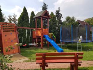 a playground with a slide and a swing set at Domki całoroczne "Leśny Zakątek" in Kątno