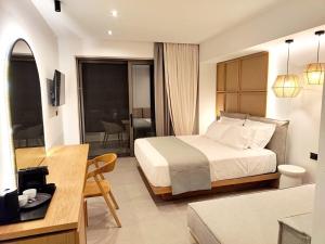 a bedroom with a bed and a living room at Ammos Paleochora Hotel in Palaiochora