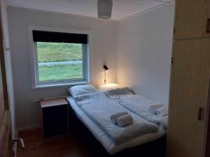 a large bed in a room with a window at Fjord Guesthouse in Funningsfjørður